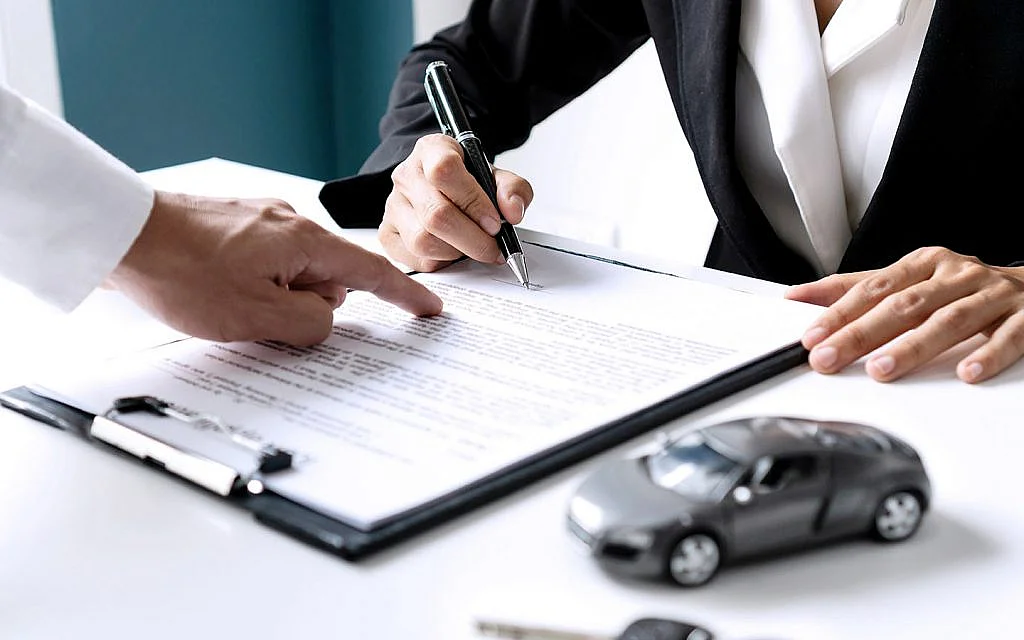 Car rental agreement signing with vehicle booking documents in Dubai